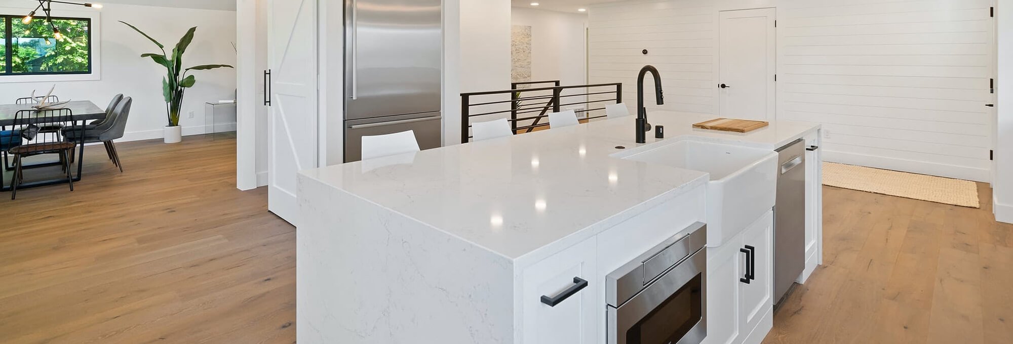 Modern all white kitchen with hardwood flooring from Richmond Flooring Showroom in Mount Pleasant, Utah